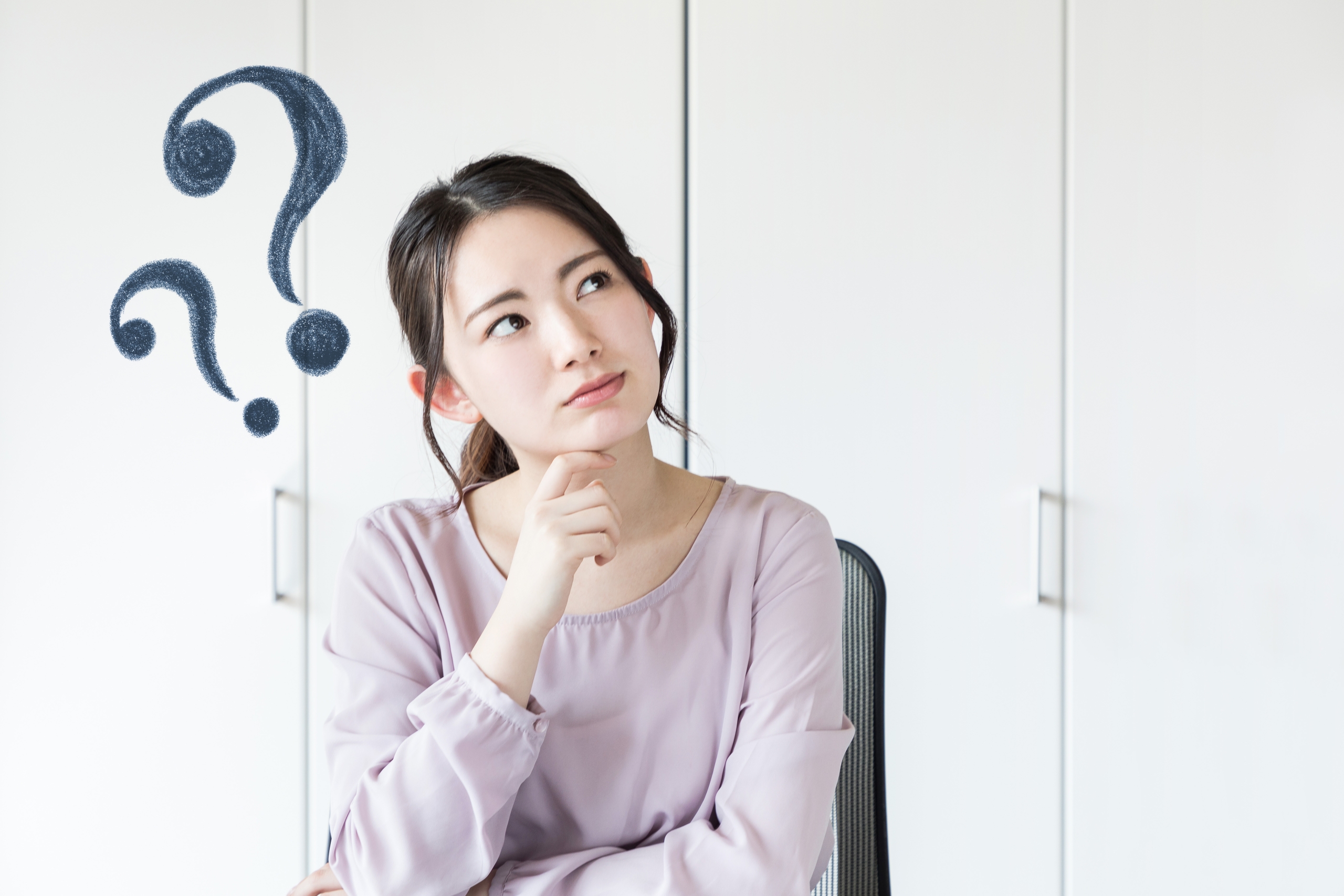 顎に手を当てて考え込むような表情を見せる女性と、頭上に描かれた疑問符（クエスチョンマーク）